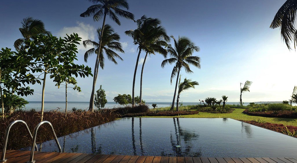 Beachfront infinity pool and palms on the Zanzibar coast