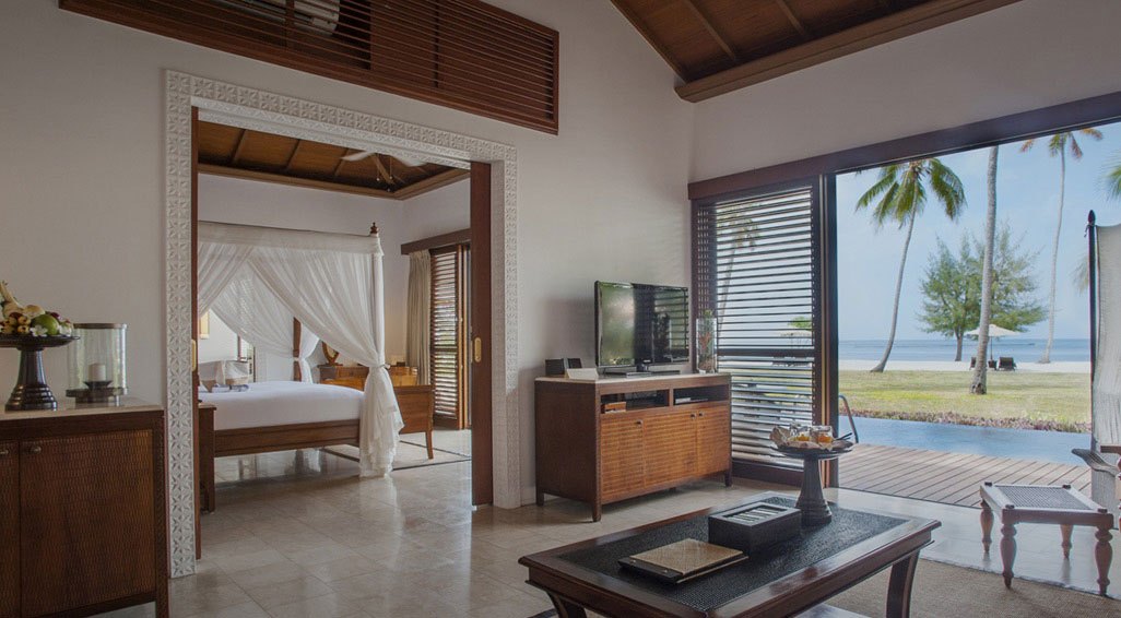 The Residence Zanzibar — Villa bedroom and lounge opening onto the pool.