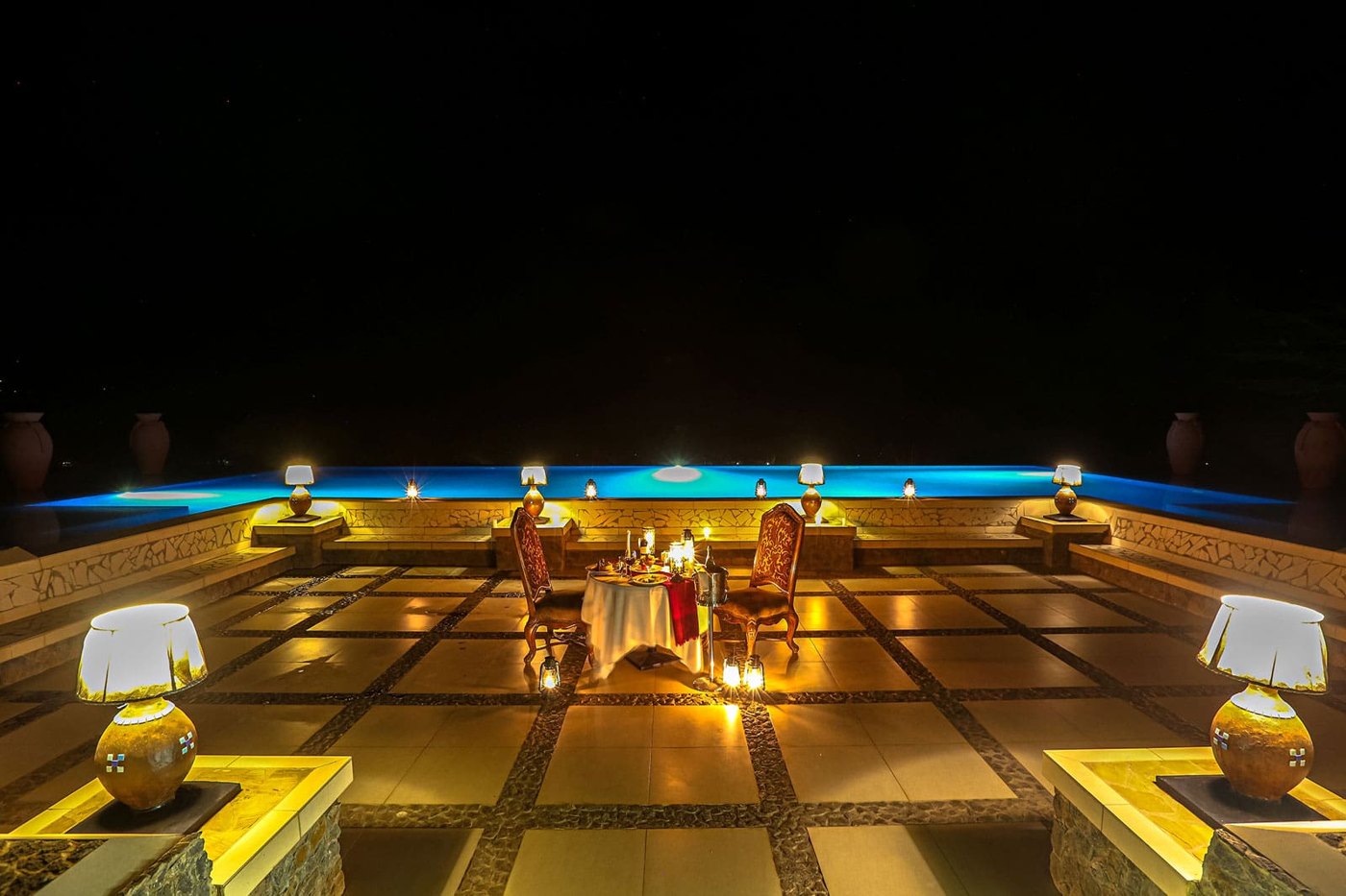 Lake Manyara Kilimamoja Lodge — Pool terrace illuminated after sunset.