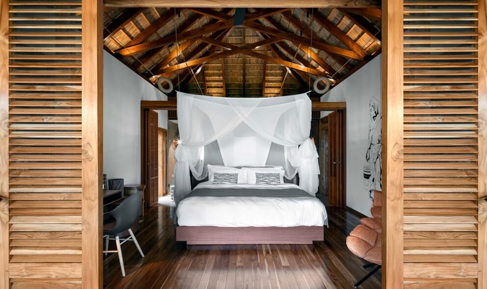 Zuri Zanzibar — Bungalow bedroom framed by timber shutters.