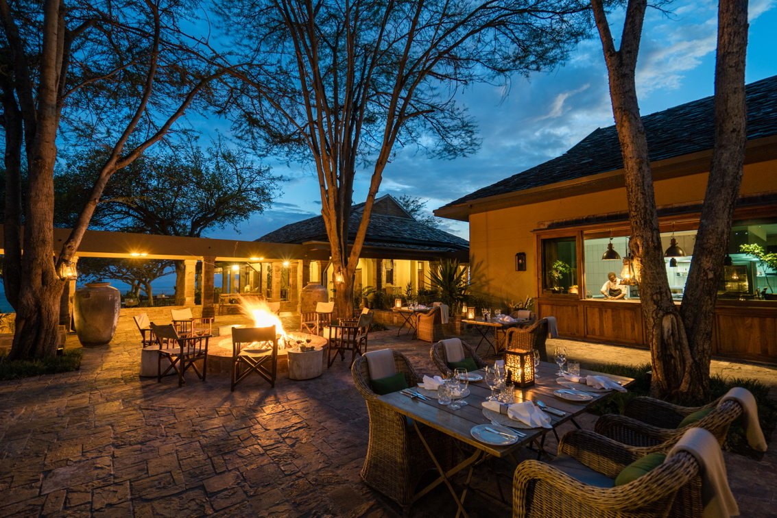 Singita Sasakwa Lodge — Outdoor dining terrace at dusk.