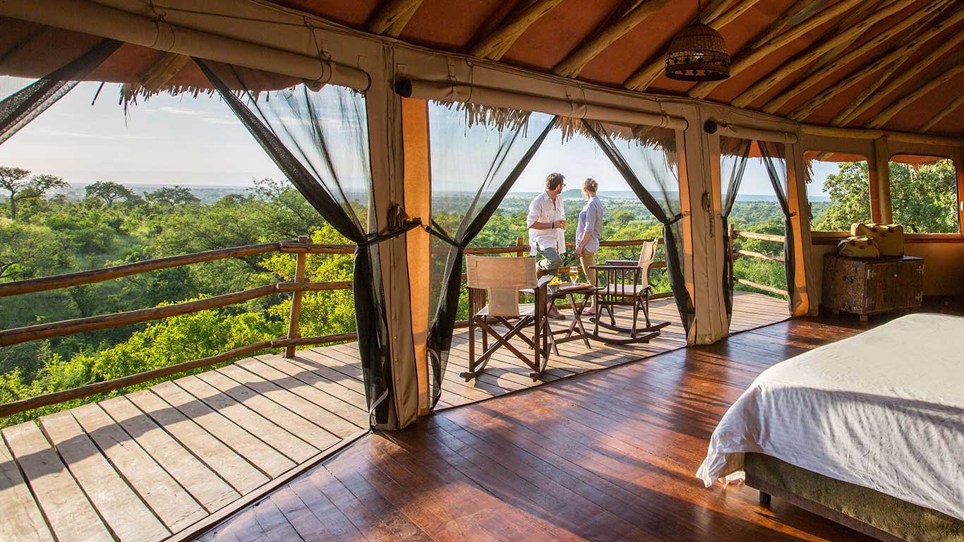 Tarangire Treetops — Treehouse bedroom opening onto the private deck.